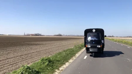 De ijsmobiel ijskar rijdt op een rustige weg door de natuur