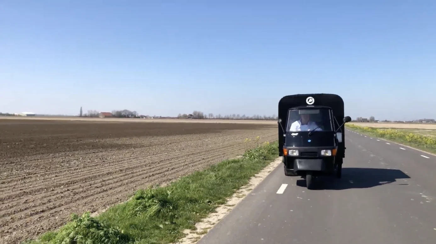 De ijsmobiel ijskar rijdt op een rustige weg door de natuur